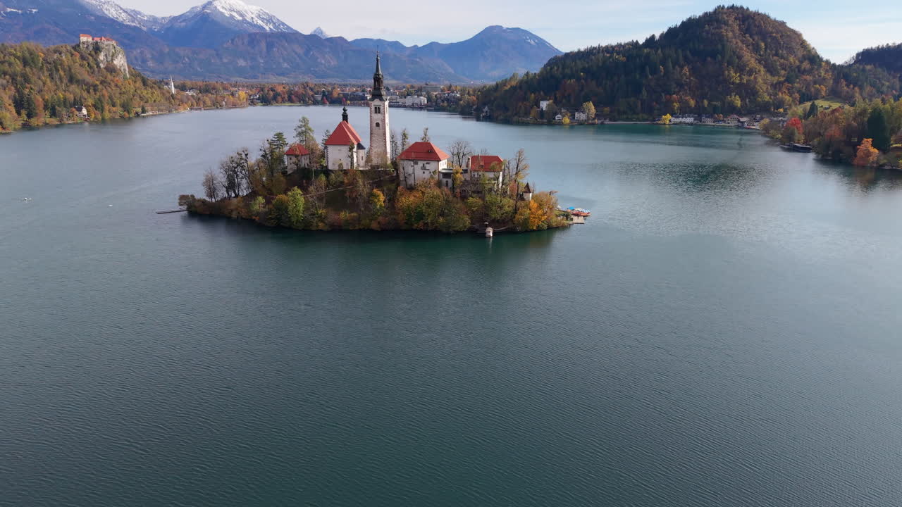 Aerial view revealing Bled Island and its church on Lake Bled in Slovenia during autumn