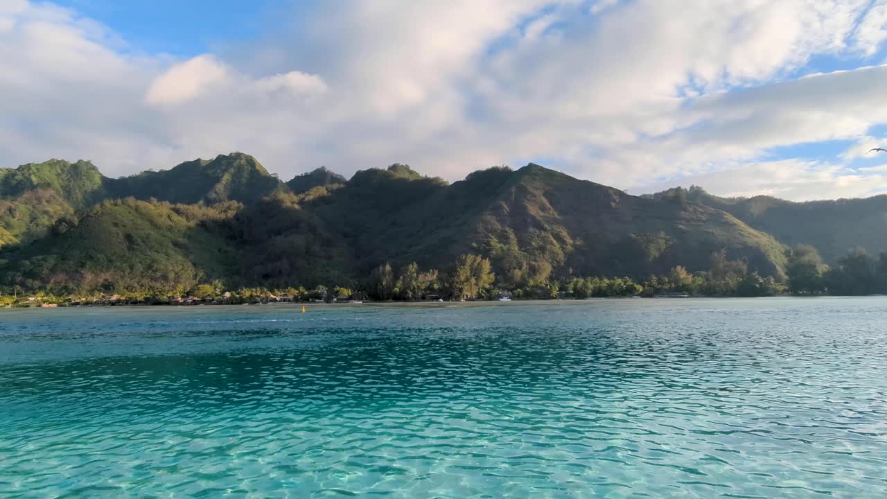 Scenic view of rugged mountainous landscape and turquoise ocean water on tropical island of Moorea in French Polynesia, South Pacific