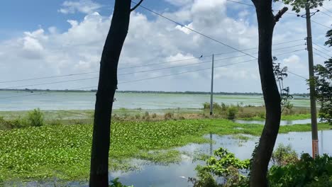 Sylhet-establisher-shot-of-flooded-river-in-Bangladesh,-fpv-from-moving-vehicle