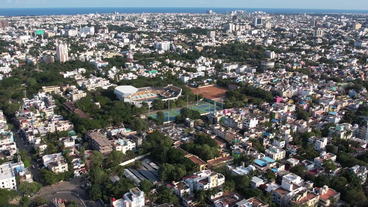 toma aérea de la cancha de tenis en medio de la ciudad india de chennai y el horizonte es azul con vista a la playa