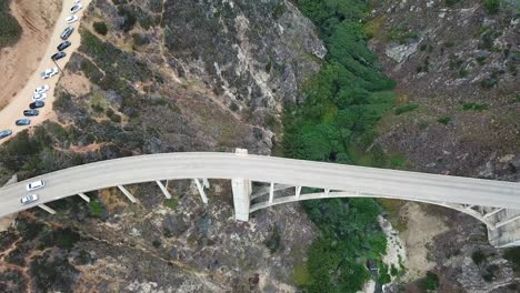 cars drive on bixby canyon bridge near big sur coast in california