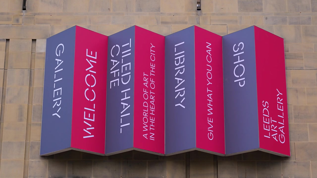 Barevné skládané panely na fasádě Leeds Art Gallery uvádějí galerii, kavárnu, knihovnu a obchod tučným svislým textem.