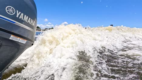 boat engine creating waves on a sunny day