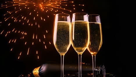 three glasses of champagne celebrating with fireworks