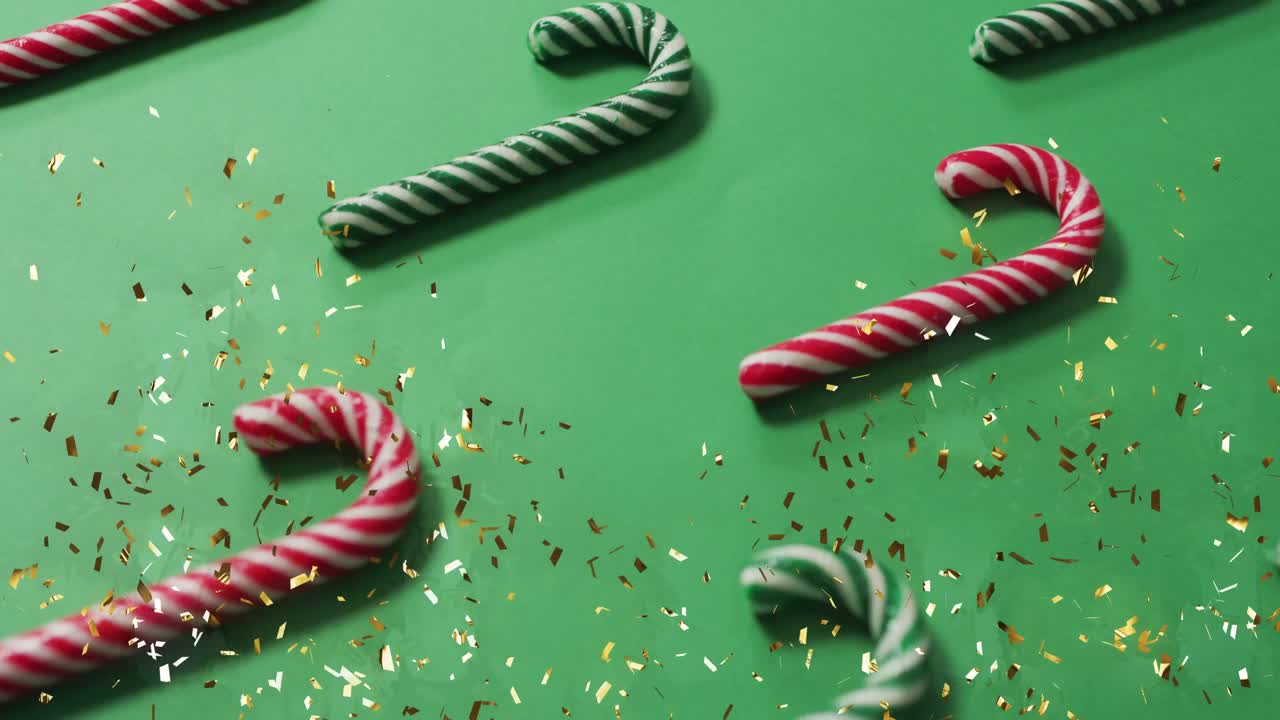 animación de confeti cayendo sobre las cañas de caramelo de navidad sobre un fondo verde.