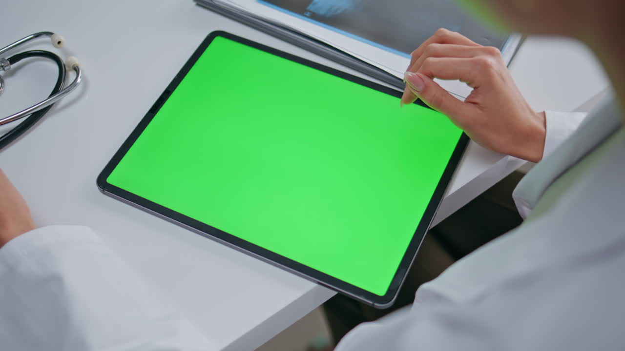 Doctor touching greenscreen tablet in clinic office closeup. Woman therapist