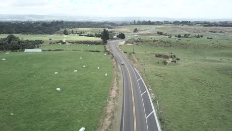 Aerial view of a road through green fields