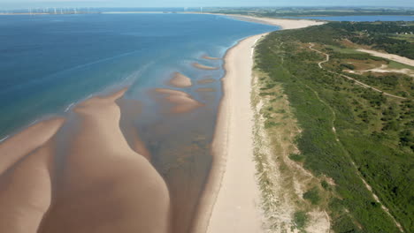 Luftaufnahme-Des-Weißen-Sandstrandes-Mit-Dünengras-Bei-Ebbe