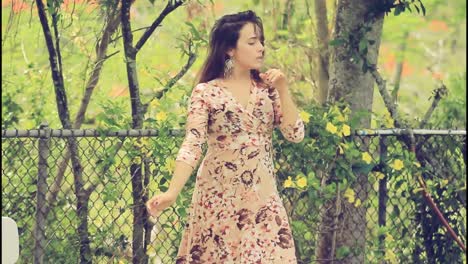 mujer bailando en un vestido floral en un jardín