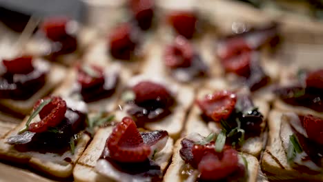 Raspberry-and-Prosciutto-mini-toast-bite-tapas-appetizer,-Close-up-macro-handheld-shot