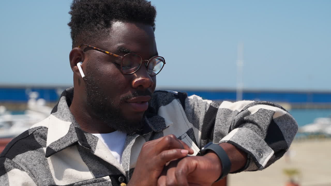 hombre comprobando el reloj inteligente al aire libre