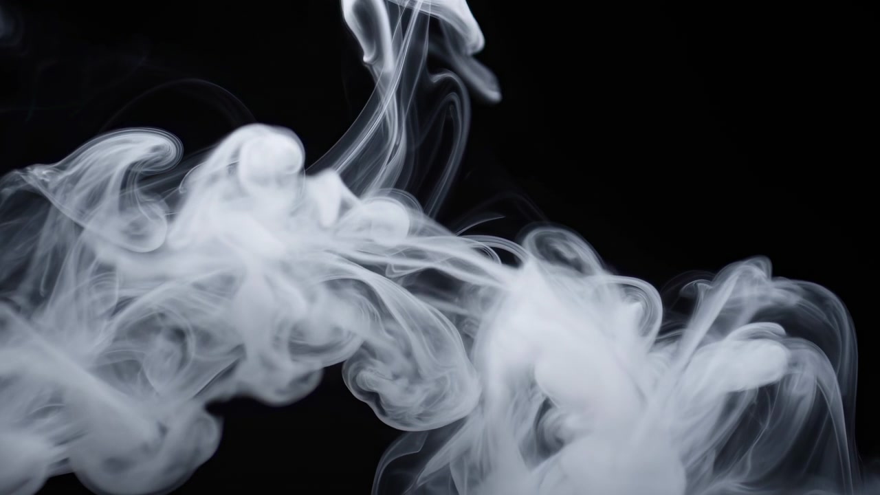 Fumo bianco e morbido si arriccia e si diffonde su uno sfondo nero, creando una scena astratta suggestiva e ad alto contrasto con un movimento fluido e morbido e volute traslucide.