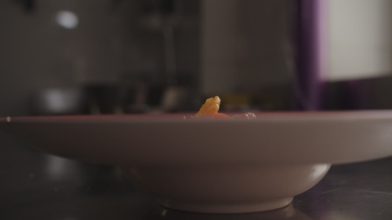 Adding an ingredient to a bowl or plate during food preparation