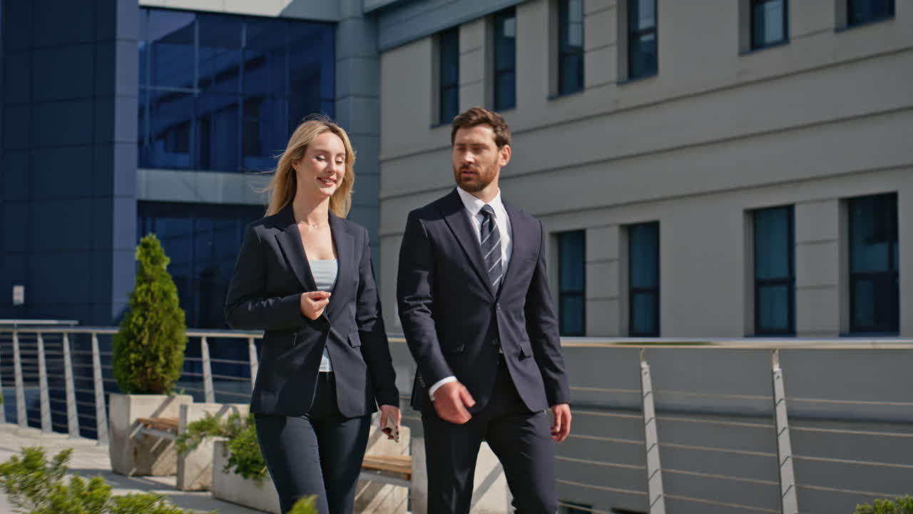 Colleagues walking together outside urban office building discussing strategy