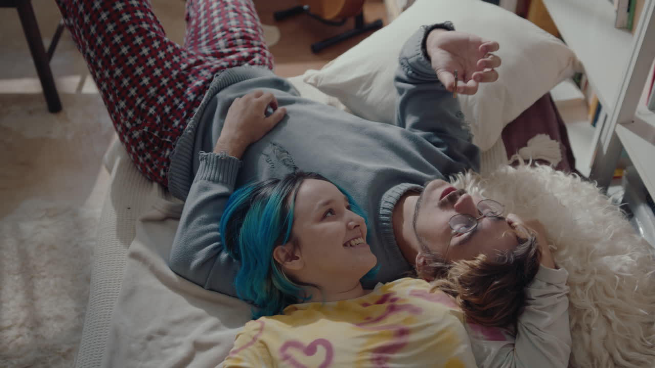 Young Couple in Love Relaxing on Bed and Smoking a Cigarette