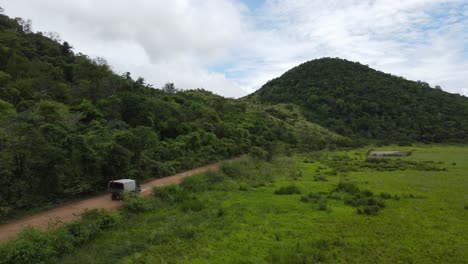 Aerial-View-of-Truck-on-Dirt-Road-in-Green-Landscape-of-Guyana,-South-America,-Drone-Shot