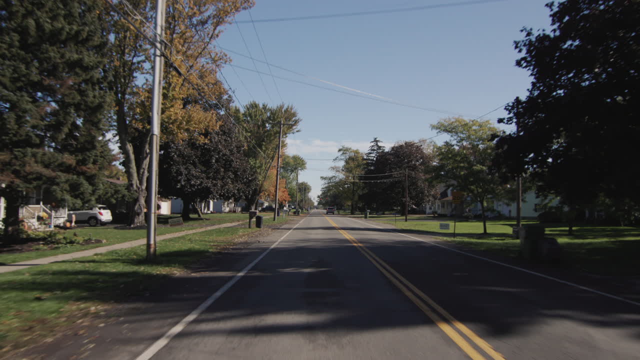전형적인 미국 농업 지역에서 평평한 도로에서 직선으로 운전. 뒤쪽 전망