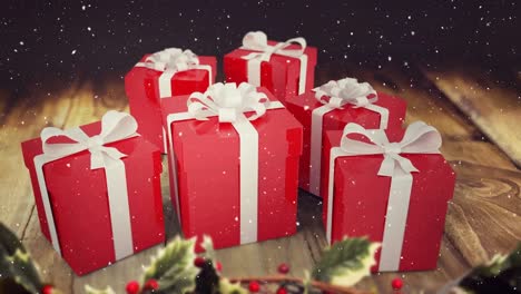 animation of snow falling over snowman with red christmas presents on wooden boards