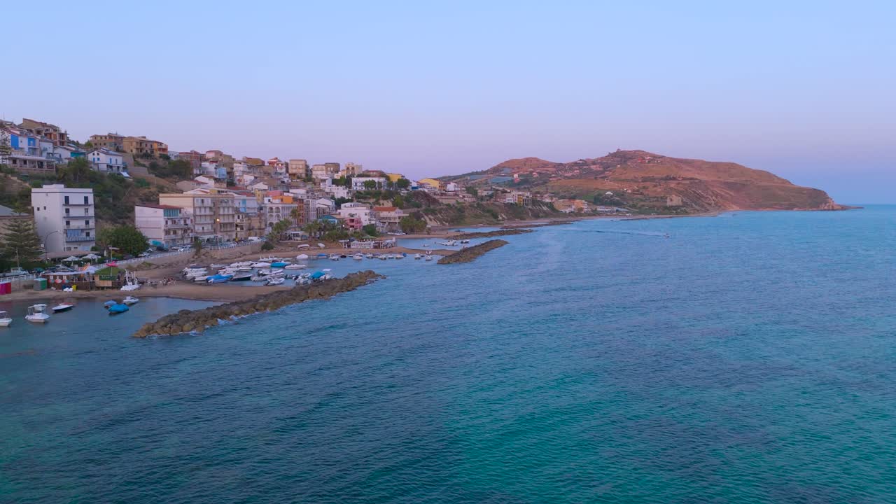 Drone shot capturing a town located at Marina di Palma in Sicilia. Turquoise water sea