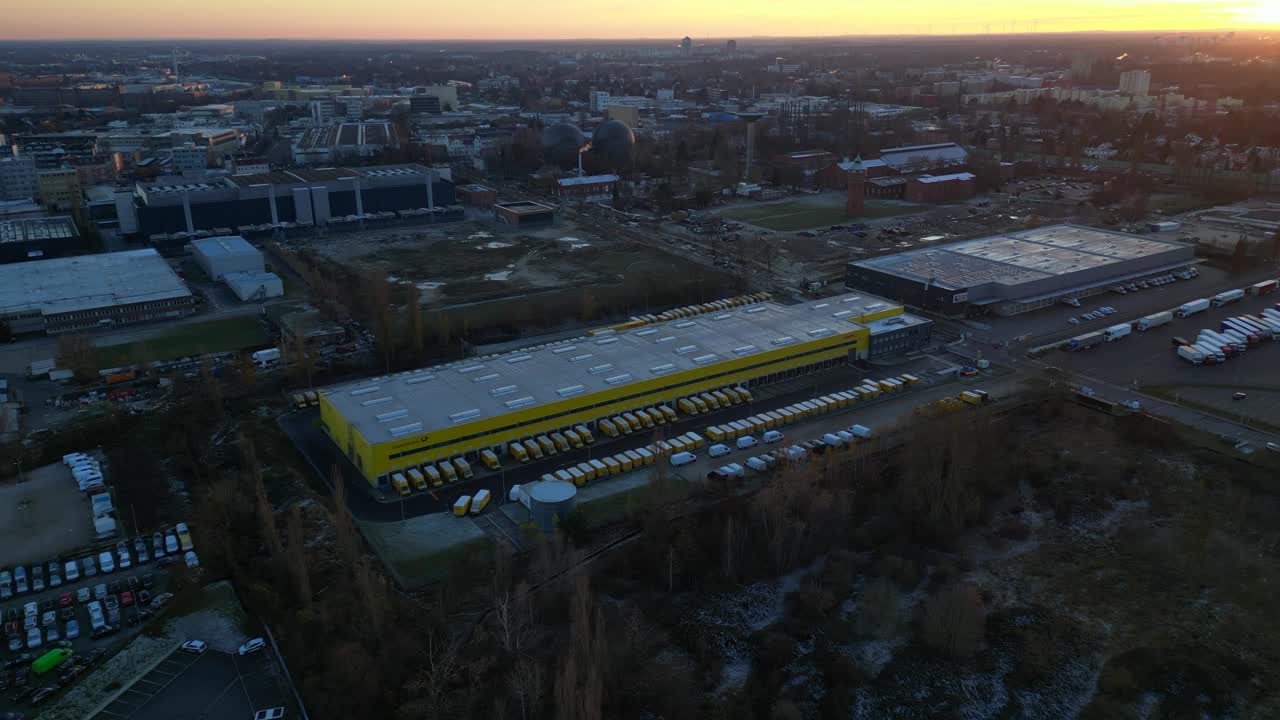 Many yellow Post delivery vans parked at a large logistics warehouse in berlin. Best aerial view flight static tripod hovering drone
