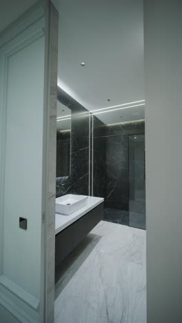 contemporary bathroom with marble accents and vertical lighting