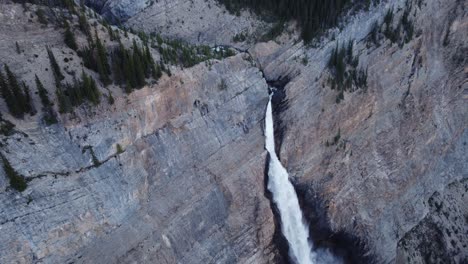 waterfall high in the mountains tilt pan circling