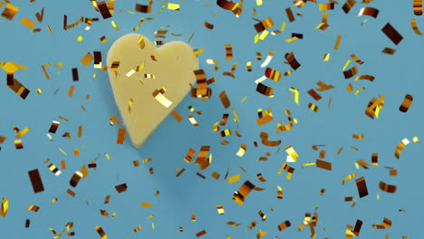 gold confetti falling over heart shape on blue background animation