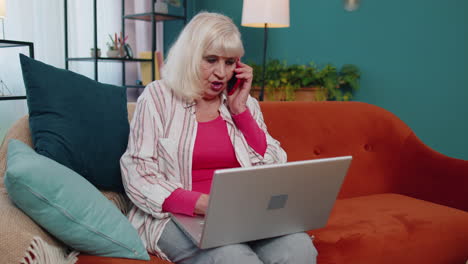 la abuela trabaja en la computadora portátil en la oficina de casa hace llamadas de negocios disfruta de una agradable conversación por teléfono móvil