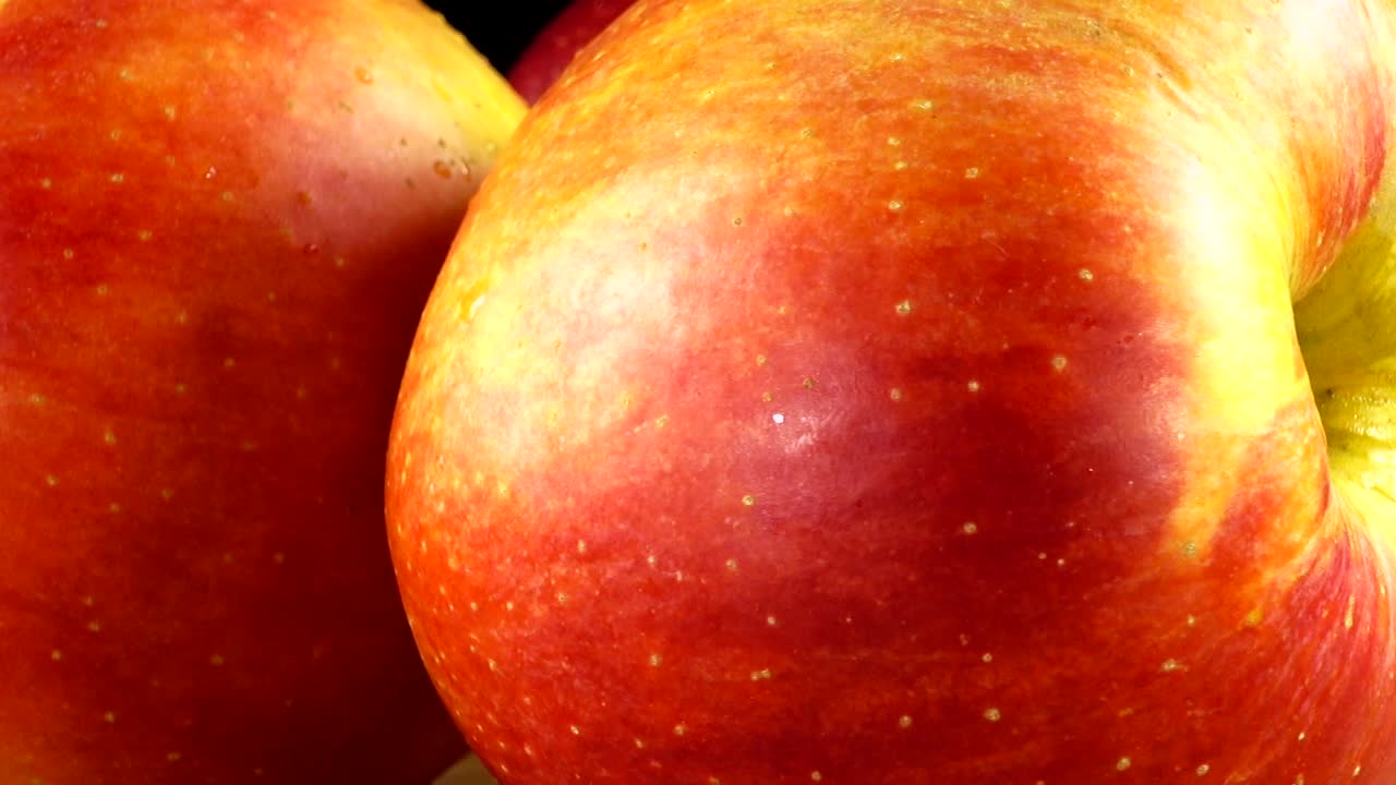 Apples on a black background. Cutting board in the movement