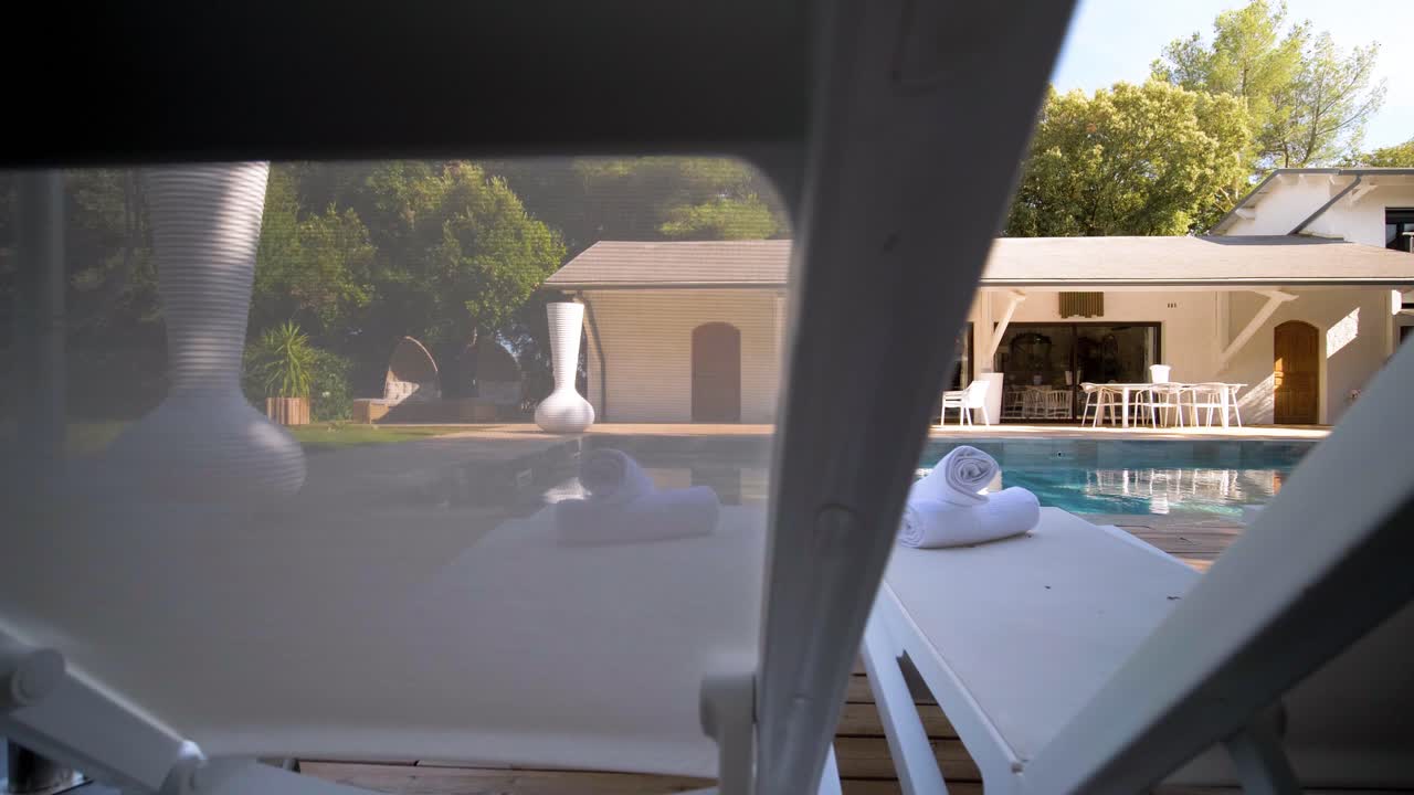 Leisure chairs set by the outdoor swimming pool, offering a stylish and relaxing atmosphere at Maison Vias, France. Modern outdoor design perfect for tranquil lounging and poolside comfort.