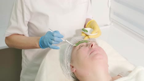 procedimientos profesionales de cuidado facial en la clínica de cosmetología moderna. aplicación de máscaras faciales
