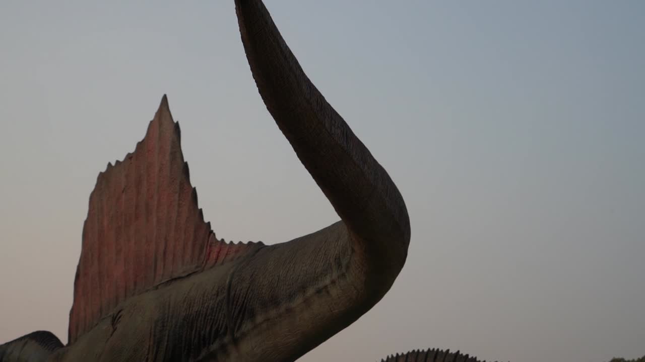 느린 동작으로 흔들리는 실물 크기의 애니메트로닉스 공룡 꼬리