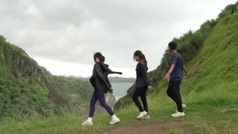 friends hiking on a mountain trail with ocean view
