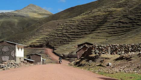 Motorcyclist-travelling-through-village