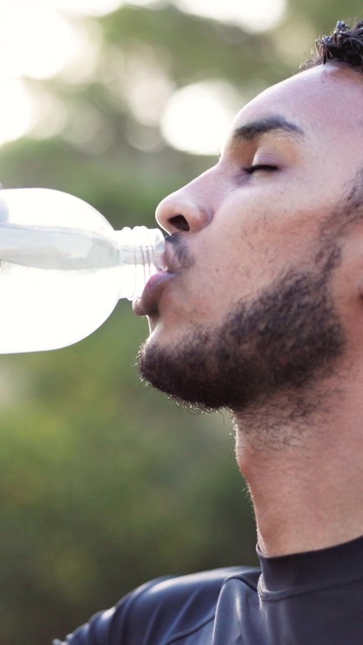 Young Man Drinking Water After Workout Outdoors