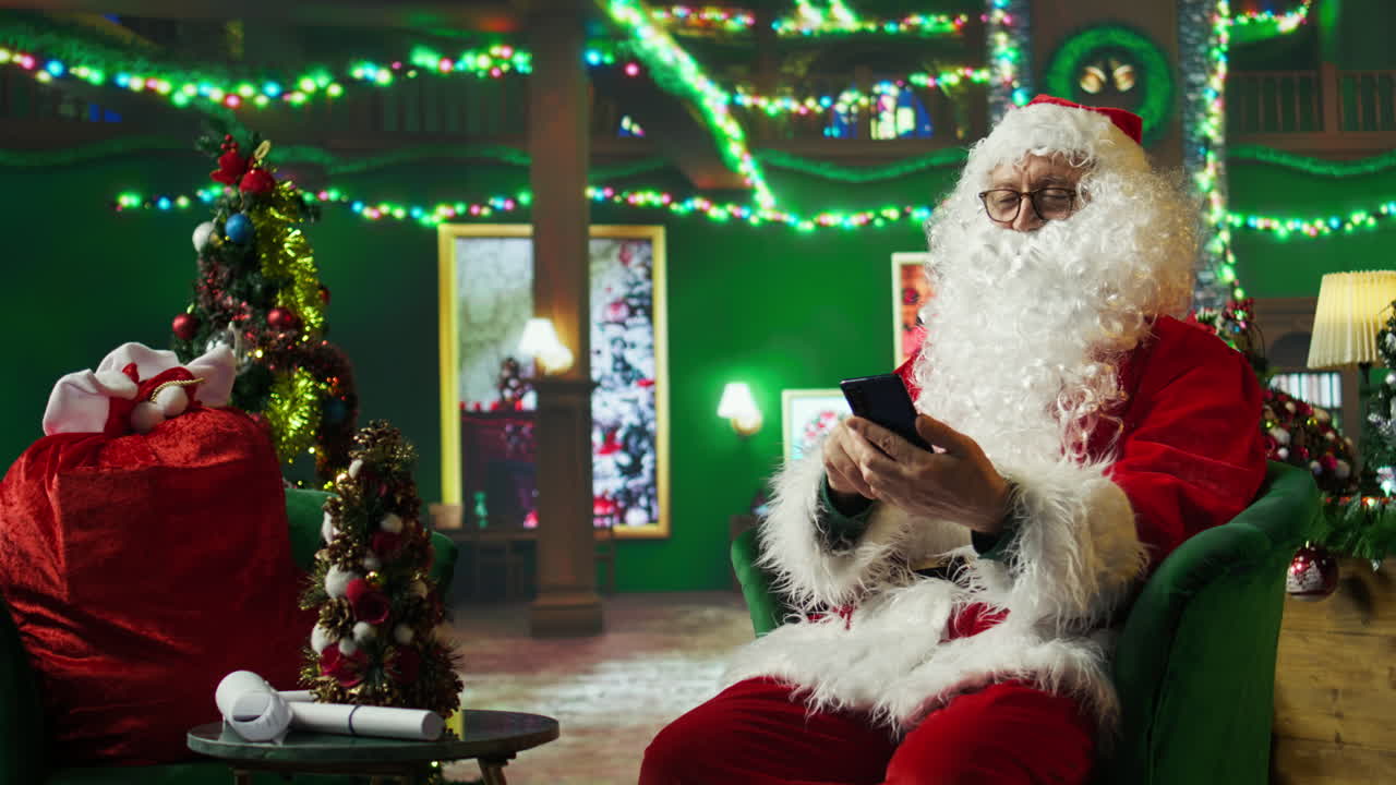 산타클로스가 크리스마스 시즌에 스마트폰을 사용하고 있습니다.