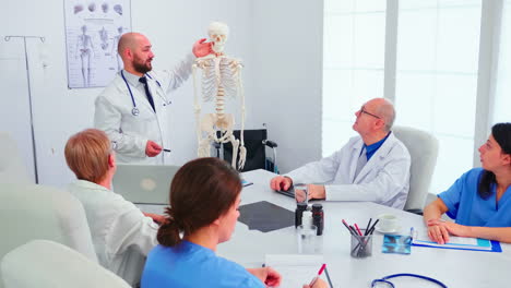 expert radiologist demonstrating on skeleton during briefing