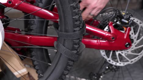 unpacking a new mountain bike, hand removing velcro straps from wheel