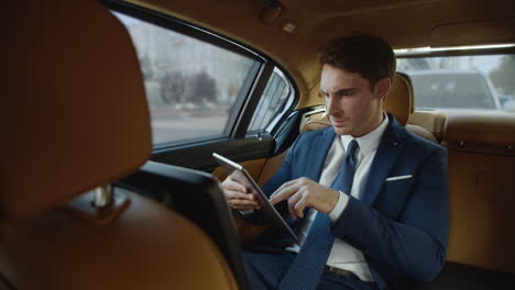 Un-Hombre-De-Negocios-Molesto-Viendo-Malas-Noticias-En-Una-Tableta-En-Un-Auto-De-Negocios-De-Lujo.