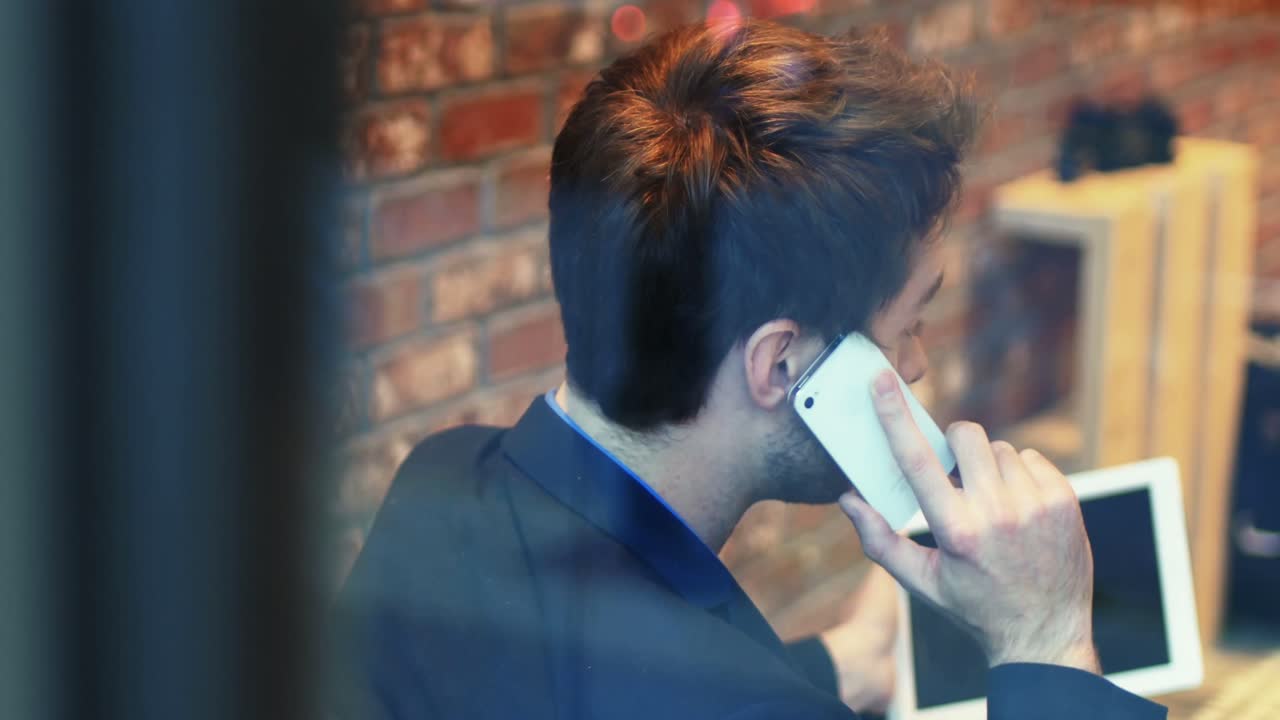 디지털 태블릿 을 사용 하는 동안 휴대 전화 로 이야기 하는 사람