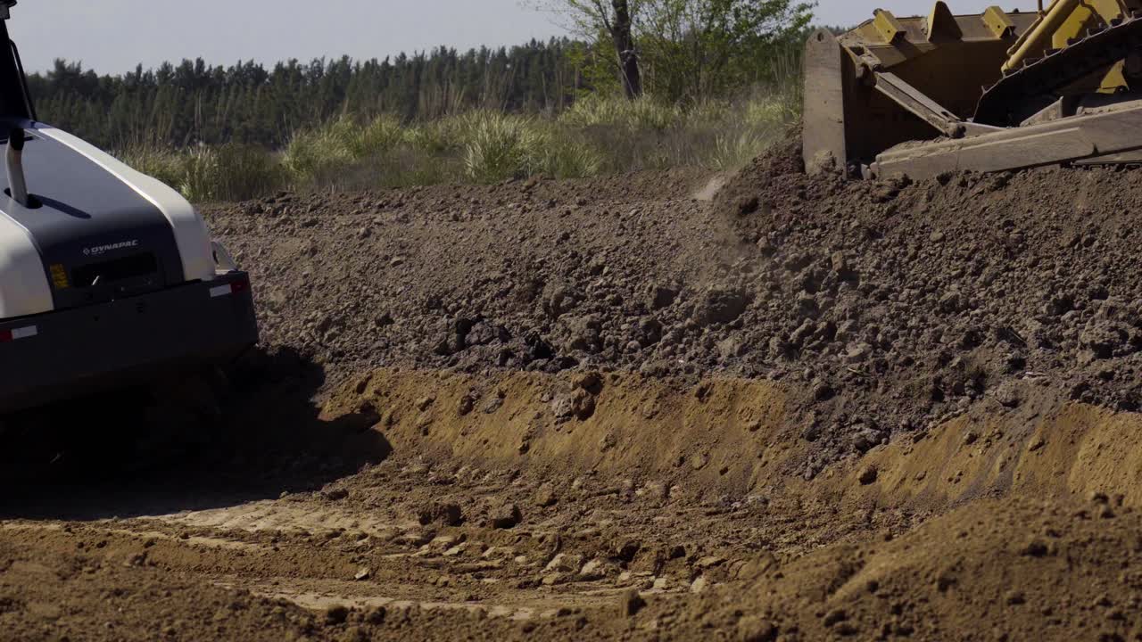 camiones de carga pesada moldeando laboriosamente el terreno para la construcción de edificios