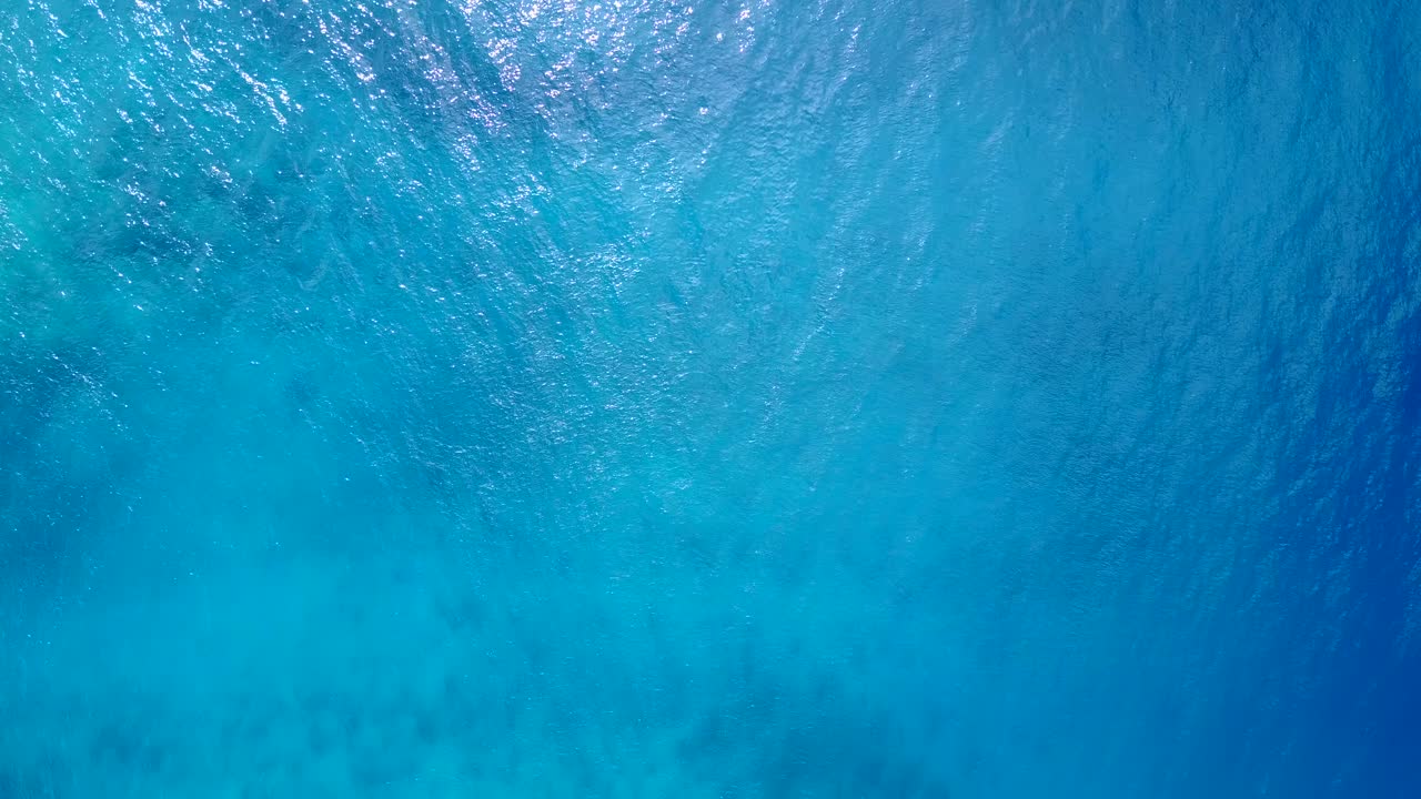 바하마 해안선의 햇빛을 반사하는 생동감 넘치는 수면을 갖춘 아름다운 푸른 바다 질감, 복사 공간