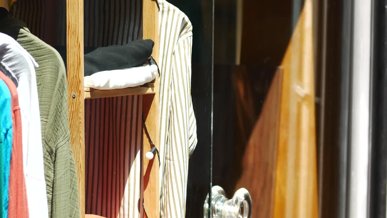 Esposizione di vestiti su stender in legno