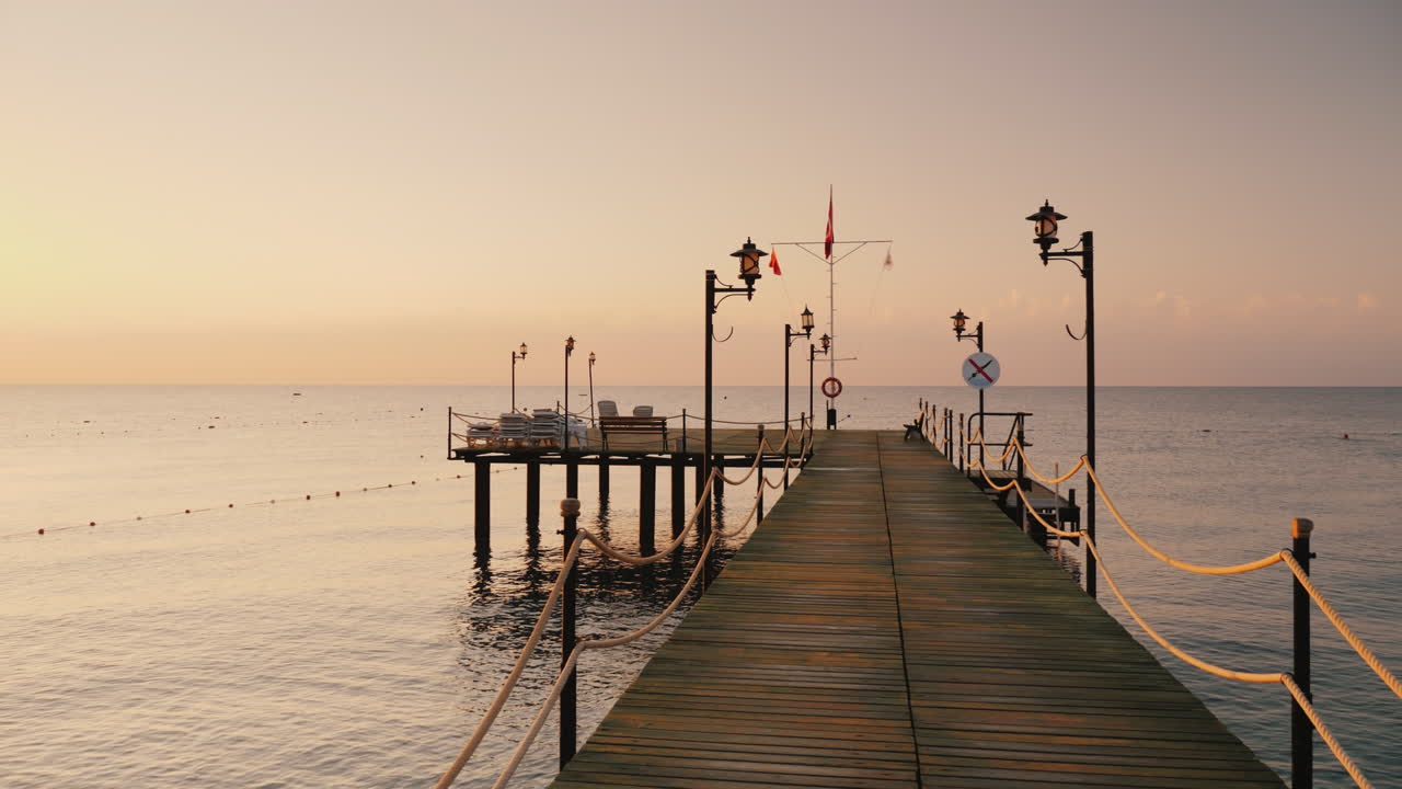 camine por el muelle hasta el mar una vista en primera persona temprano en la mañana al amanecer tiro de steadicam