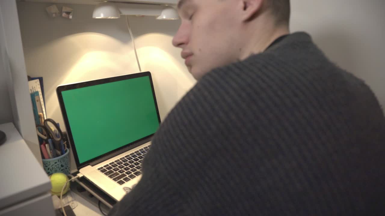 Side View Of A Young Man Sitting In Front Of Its Laptop And Checking Out The Time On His Wristwatch, Feeling Tired.- closeup shot