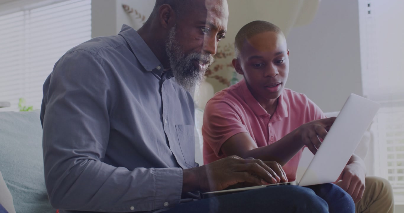Dad following son pointing, typing on laptop while network tech graphics gradually enabling sharing