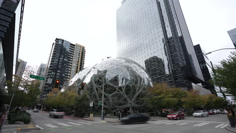 timelapse of the spheres at amazon, with cars and pedestrians moving along lenora st and 7th ave. the iconic glass domes stand among modern skyscrapers, capturing the flow of urban life.