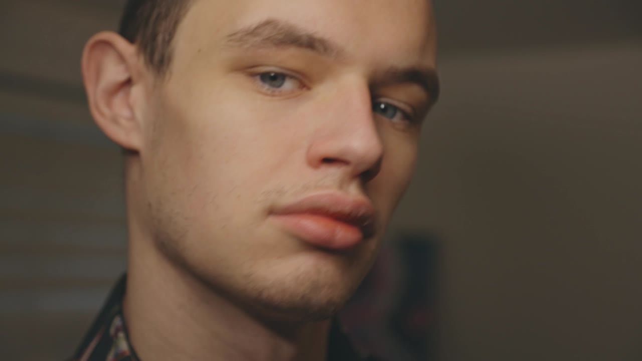 Young Man Looking In Front Of The Camera Moving His Head From One Side To The Other - Closeup Shot