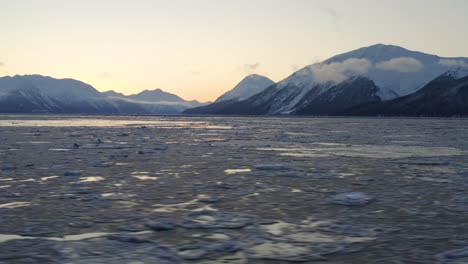 Majestic-landscape-of-Cook-Inlet-with-Alaska-Mountains-during-sunset,-low-aerial