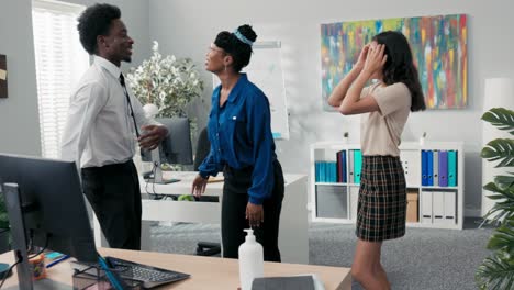 dance at work, office, break from duties, company party, two girls and a man in a shirt and tie dancing together, fooling around, laughing, smiling, relieving stress, music playing from the computer